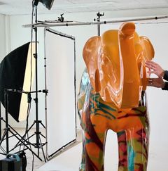 Orange og grøn elefantfigur ses i fotostudie.