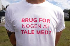 Billede af ung mand i t-shirt med teksten "Brug for nogen at tale med?"