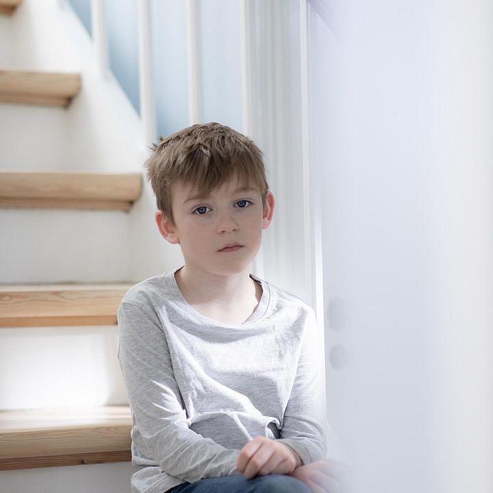 Dreng sidder på trappe