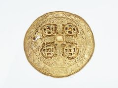 Hornelundespænde 2 Skatten er fundet tæt ved Varde i 1892. Den indeholder en armring og to dragtspænder af guld. De to spænder er blandt de fineste eksempler på guldsmedekunst fra Danmarks vikingetid. De fire dyrehoveder i nordisk stil omkring midten på det ene spænde viser, at de er fremstillet af en dansk guldsmed i begyndelsen af 1000-tallet.