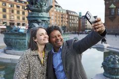 Glade turister der tager selfie på Rådhuspladsen