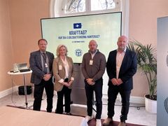 Fyra personer står framför en skärm som visar texten "Krafttag? Hur ska elbilsbatterierna hanteras?"