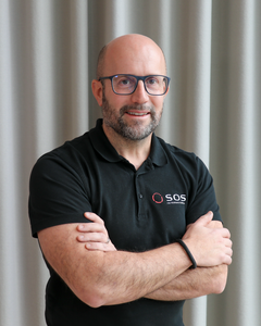 Man i svart tröja med SOS-logotyp.