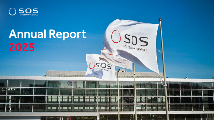 Bilde av flagg med SOS International-logoen foran en moderne kontorbygning.