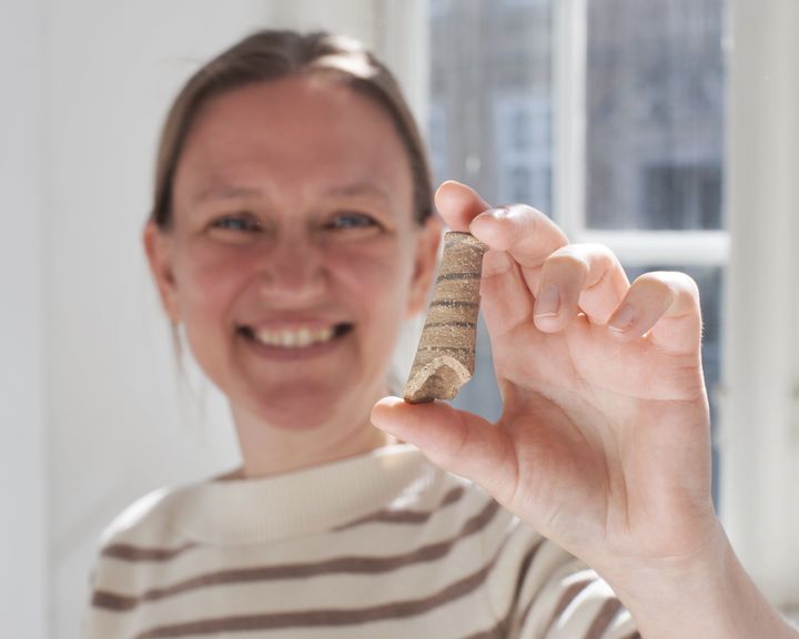 Mette Marie Hald med et fragment fra en af oldtidens babyrangler. Foto: Jacob Hald, Nationalmuseet.