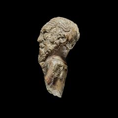 Vikingefigur set fra siden, på sort baggrund. Foto: Roberto Fortuna, Nationalmuseet.