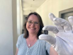 Gitte Tarnow Ingvardson with one of the coins. Photo: John Fhær Engedal Nissen, the National Museum of Denmark.