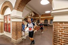 Tre personer løber gennem en gang på Læssøesgades Skole.