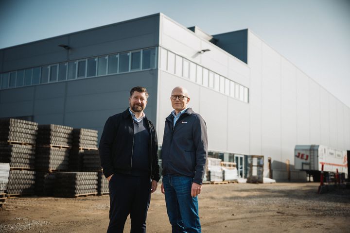 Logistikdirektør Jan Breinholt fra STARK og salgsdirektør Kim Ebbe Jakobsen fra Element Logic foran byggekædens kommende nationale distributionscenter i Brøndby, hvor AutoStore‑robotlageret bliver en stærk motor i den nye logistikløsning.