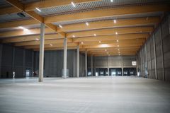 De gennemgående limtræsspær spænder over lagerhallerne og erstatter traditionelle betonkonstruktioner, hvilket bidrager væsentligt til det lave CO₂-aftryk.