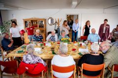 En gruppe mennesker samles omkring et spisebord på Plejecenter Toftegården under et arrangement om dysfagi og demensvenlige spisefællesskaber.