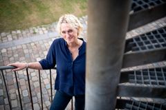 Theresé Andersen, fagchef for Arbejdsmarkedet i Tønder Kommune, står på en trappe og smiler til kameraet.
