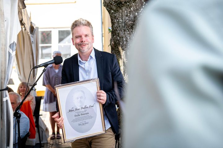 En person modtager en pris til en ceremoni.