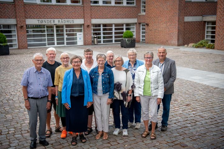 En gruppe mennesker står foran en bygning med skiltet "Tønder Rådhus".