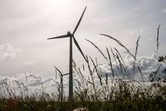 To vindmøller i en mark under overskyet himmel.