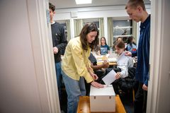 En gruppe unge deltager i en afstemning under et møde.