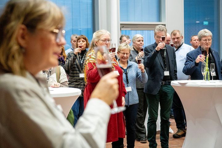 Gruppe mennesker skåler ved et netværksarrangement.