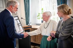 Borgmester overrækker pris til tekstilkunstner, der assisteres af sit barnebarn.