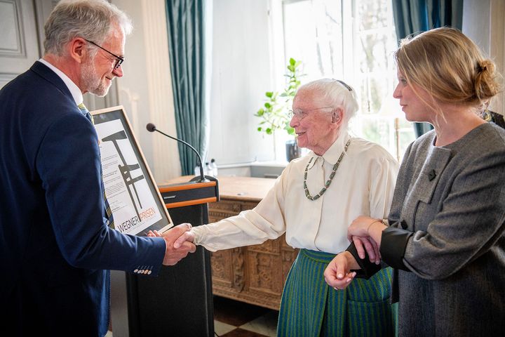 Borgmester overrækker pris til tekstilkunstner, der assisteres af sit barnebarn.