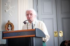 En ældre kvinde står ved en talerstol og holder en tale.