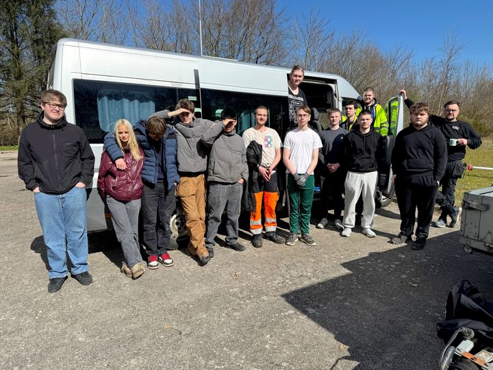 En gruppe FGU-elever står foran en minibus.