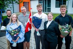 Gruppefoto af prisvindere ved Fest for Fremtidens Faglærte med blomsterbuketter.
