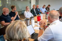 En gruppe mennesker sidder rundt om et bord til et møde.