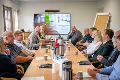 En gruppe mennesker sidder omkring et bord under et møde i Tønder Kommunes Erhvervsstrategiske Forum.