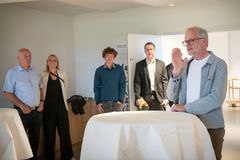 En gruppe mennesker står i et rum på Museum Wegner i Tønder. En mand taler til de andre, der ser opmærksomt på ham.