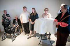 En gruppe mennesker står og sidder rundt om et bord ved en fejring på Museum Wegner i Tønder.