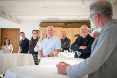 En gruppe mennesker lytter opmærksomt til en taler ved en præmieceremoni på Museum Wegner i Tønder.