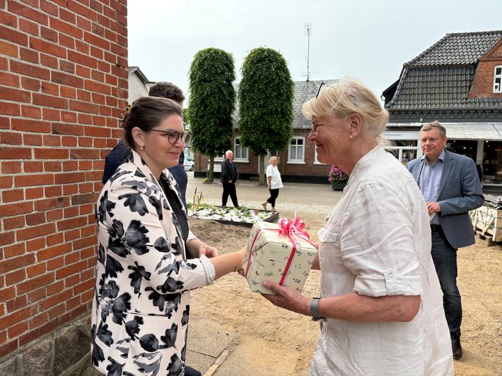 Ejeren af huset får overrakt en pakke af næstformanden i Teknik- og Miljøudvalget