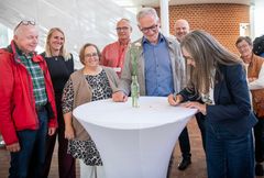 En gruppe mennesker står omkring et bord, mens to personer underskriver en aftale for at forbedre beredskabet, omkranset af Røde Kors- og Tønder Kommune-repræsentanter.