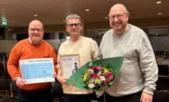 Tre personer poserer med Handicapprisen 2025 og en buket blomster.