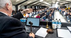 Auktionarius Finn Campen styrer slagets gang fra auktionspodiet med klokke, hammer og auktionsblok