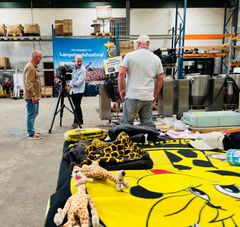 Mellem merchandise og storkøkkeninventar fra den legendariske Langelandsfestival står John Just, tidligere sikkerhedsvagt ved Store Scene. Fotograf Ken Pedersen og journalist Jesper Buch fanger det nostalgiske øjeblik, mens John Just genopliver sine gamle minder som trofast festivalgænger