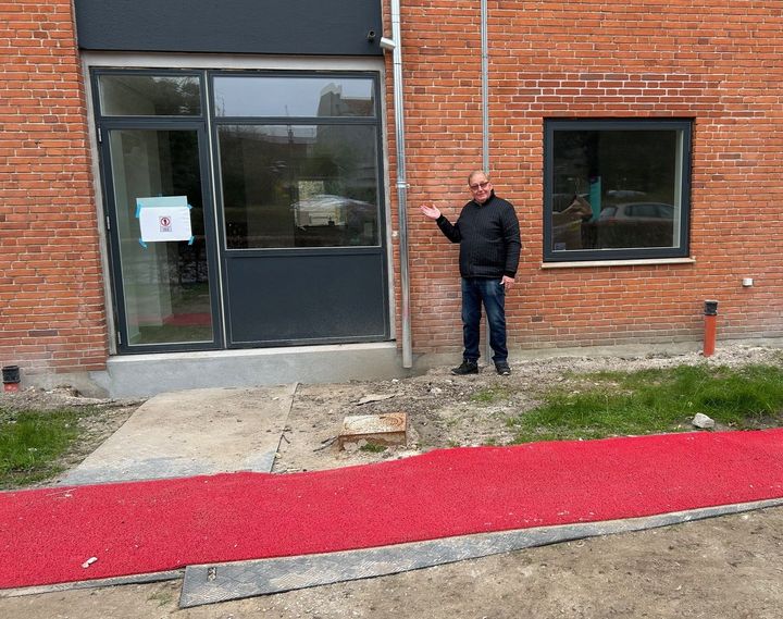 En mand står foran et nyrenoveret indgangsparti i en bygning.