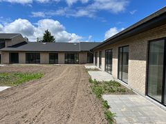Nybygget boligkompleks i Rørbækhuse med flere ensartede murstensbygninger under en blå himmel.