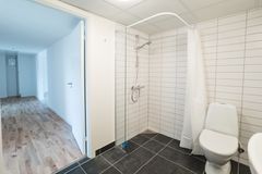 Badeværelse i en nyrenoveret lejlighed med brusekabine og toilet.