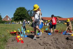 Børn arbejder og graver i en jordbunke