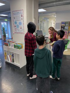 Bibliotekar hjælper tre elever med at finde bøger i Vallensbæk Kultur- & Borgerhus.