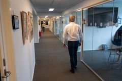 En mand går ned ad en gang i Kultur- og Borgerhuset i Vallensbæk. Væggene har glaspartier og kunstværker.