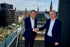 Viceadm. direktør i Arbejdernes Landsbank Frank Mortensen (tv.) og Adm. direktør i PenSam Torsten Fels giver hånd på handlen.