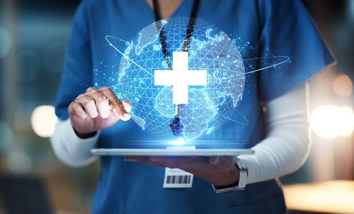 healthcare professional holding tablet with illustration of a white cross