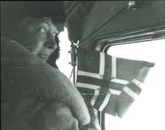 Ingrid Christensen, wife of Lars Christensen, took part in several expeditions to Antarctica and is considered the first woman to set foot in Antarctica. Here she is seen in the Stinson airplane in 1937 ready to throw a Norwegian flag over the land area in East Antarctica. Copyright Norwegian Polar Institute