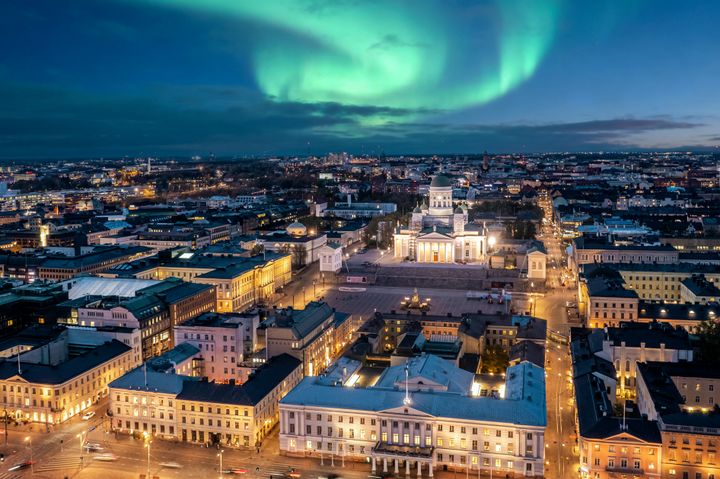 Aftenudsigt over Helsinki med domkirken i centrum og nordlys på himlen.