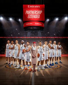 Basketballholdet står opstillet på banen sammen med en kabinemedarbejder fra Emirates.