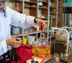 Små stykker af polyesterkjole puttes i kolbe