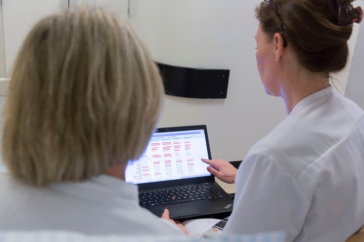 Region Midtjylland glæder sig over fokus på patientinddragelse i ny kræftplan. Regionsrådsformand, Anders Kühnau: ”Vi har i Region Midtjylland et stærkt både politisk og fagligt fokus på at tilrettelægge kræftbehandling efter patientens ønsker. Samtidig viser de erfaringer, vi gennem mere end 10 år har bygget op, at tilgangen faktisk styrker kvaliteten, og samtidig gør sundhedsvæsnet mere effektivt.” På billedet gennemgår sundhedspersoner et digitalt spørgeskema udfyldt af en patient. Foto. Region Midtjylland.