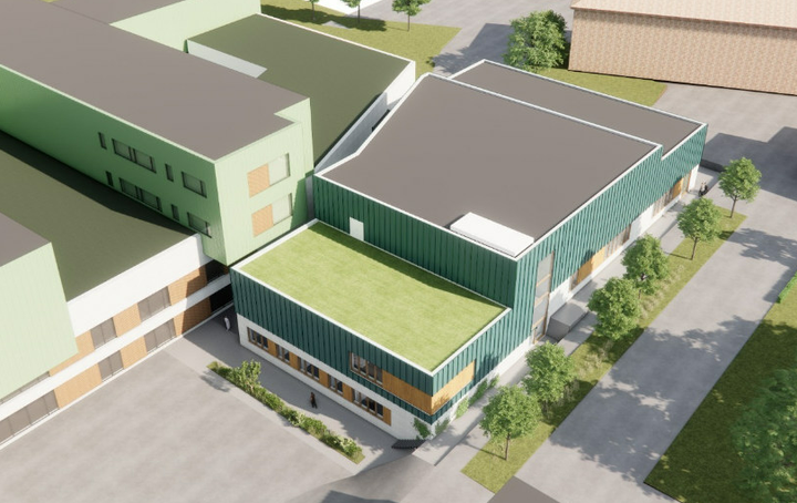 Arkitekttegning af Sterilcentralen set oppefra. Nybyggeriet bliver en firkantet bygning med fladt tag. Bygningens midterste del er højest. I stueplan er facaden hvid, mens resten er beklædt med grønne plader. Hvor bygningen forbindes til Nye Nord er huset tre etager med græs-lignende tag. Resten af bygnignen er to-tre etager højere og har mørkegråt tag.